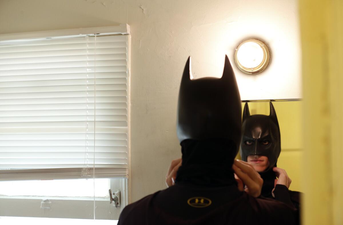 Aspiring actor Austin Franklin gets dressed up as Batman at his home in Hollywood before heading out to perform on Hollywood Boulevard on April 15, 2016.