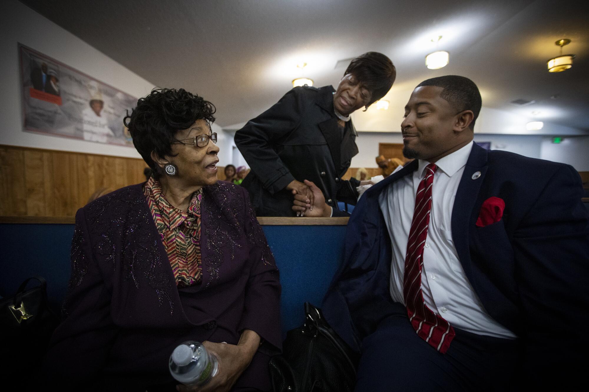 State Rep. James Coleman, right, speaks with churchgoers in Denver. 