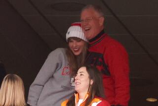 Taylor Swift hugs her dad in the stands of an NFL game they're watching