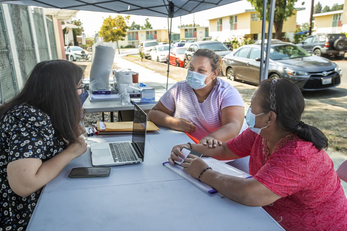 Immigration attorney Dulce Oliveira, left, answers questions for Gloria Acosta, center, with her mother, Enriqueta Ochoa.