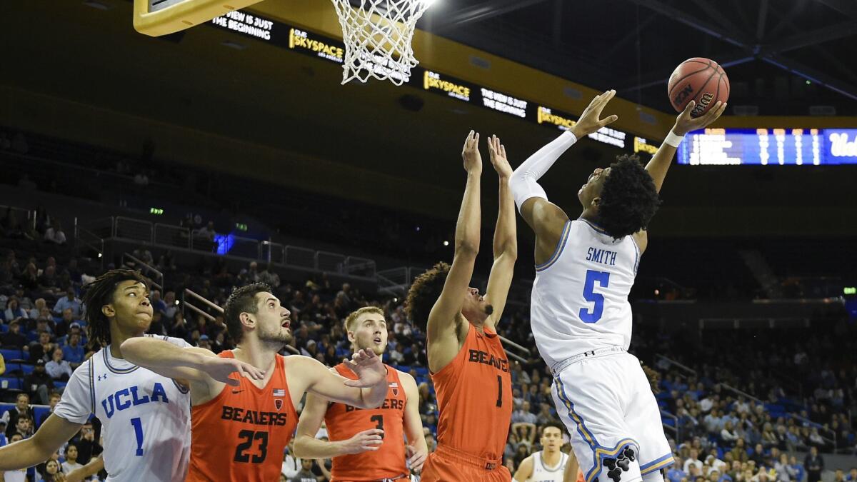 UCLA guard Chris Smith, right, drives for a layup while Oregon State guard Stephen Thompson Jr., second from right, defends during the second half.
