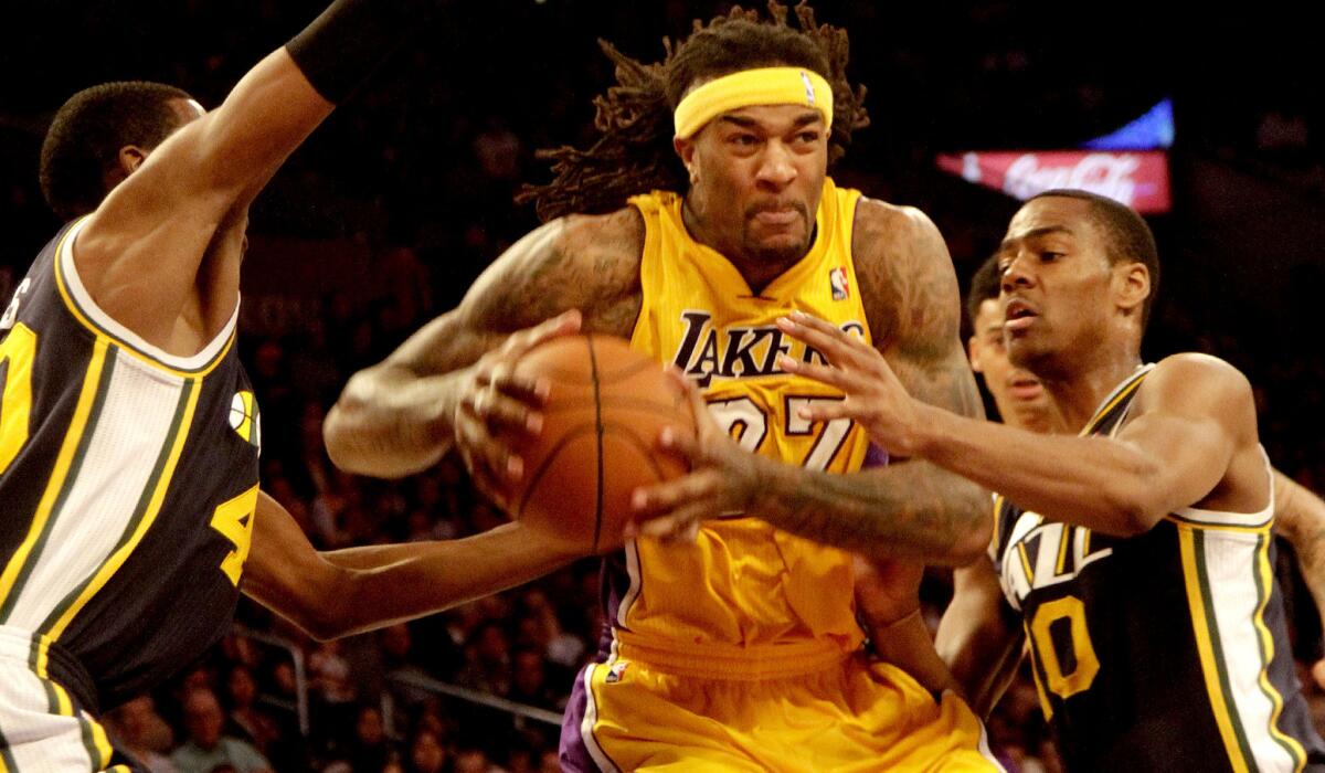 Lakers center Jordan Hill tries to power his way to the basket against the defense of Jazz forward Jeremy Evans, left, and guard Alec Burks during a game last season.