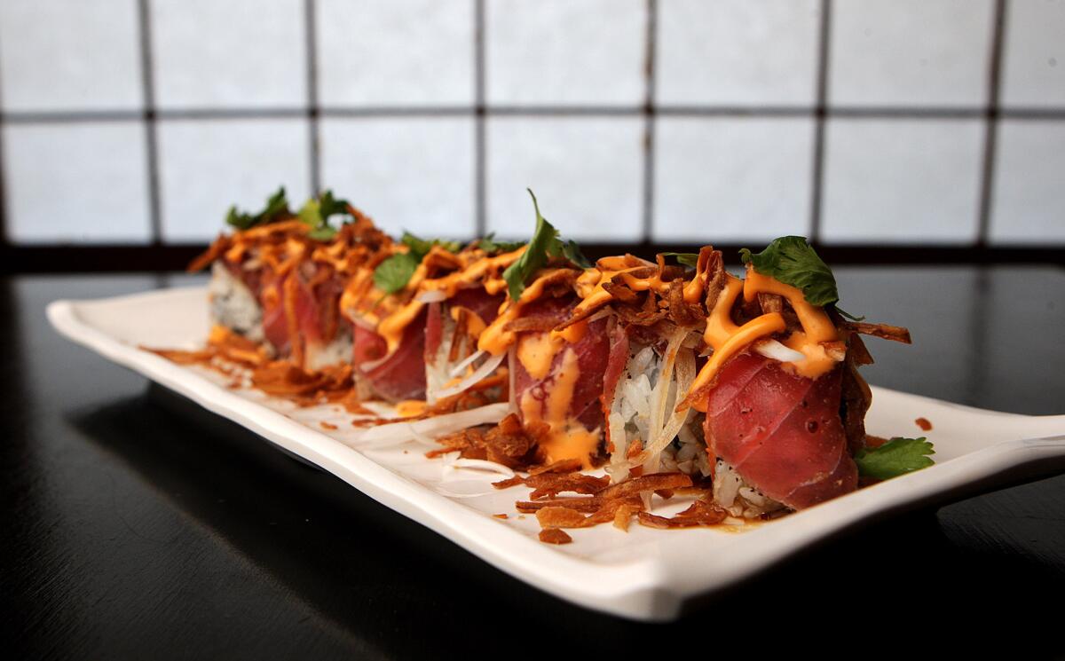 A Tataki Roll made with spicy tuna roll topped with seared tuna, cilantro, white onions, fried onions, fried garlic, garlic ponzu, mustard dressing and spicy mayo at Boku Restaurant in Glendale on Wednesday, December 31, 2014.