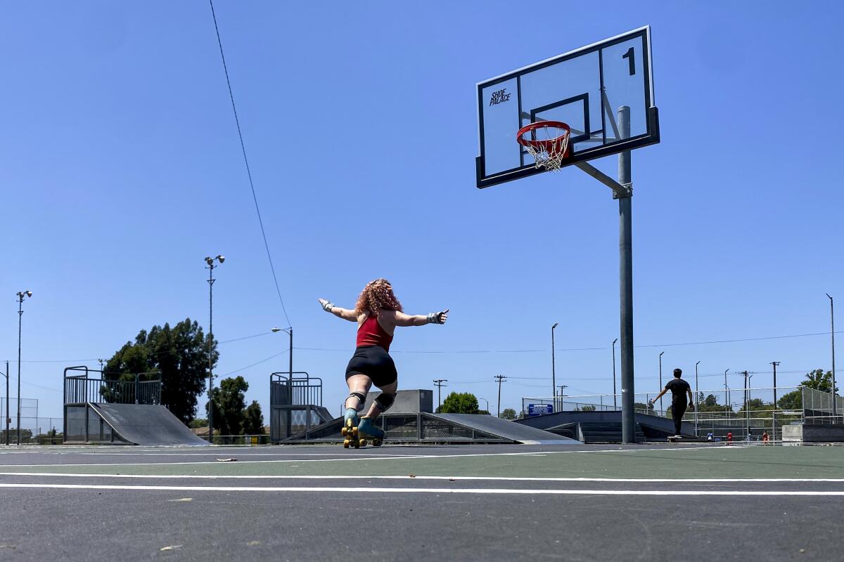 A person roller skating on an outdoor basketball court