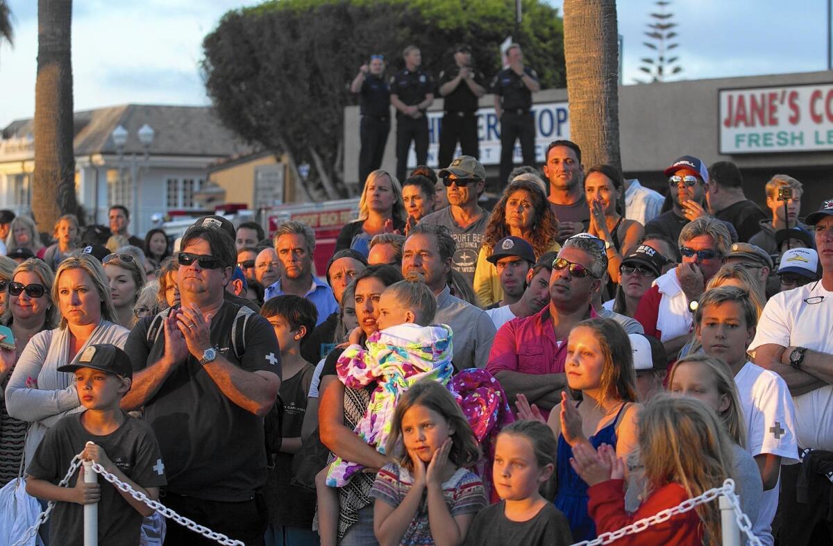 Hundreds of people gathered Wednesday evening at McFadden Square in Newport Beach for the unveiling of a stainless-steel statue of fallen lifeguard Ben Carlson.