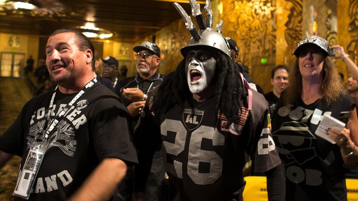 Raiders fan Ray Perez, middle, cheers with other fans as team owner Mark Davis speaks during an NFL hearing on Oct. 29 in Oakland.