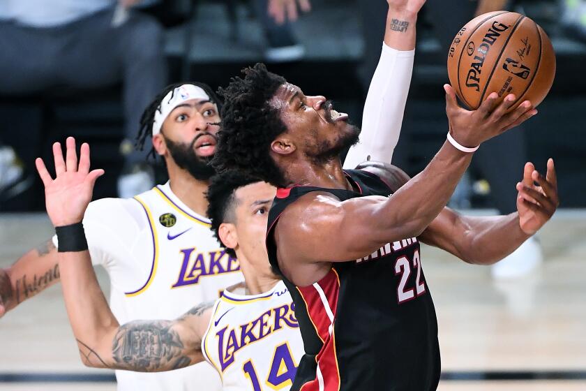 ORLANDO, FLORIDA OCTOBER 4, 2020-Heat's Jimmy Butler beats Lakers Anthony Davis, left, and Danny Green to the basket in the 3rd quarter in Game 3 of the NBA FInals in Orlando Sunday. (Wally Skalij/Los Angeles Times)
