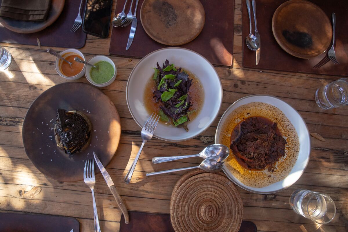 An overhead image of three lunch dishes on a wooden table.