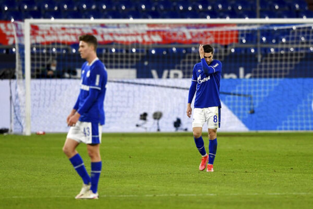 Schalke's Matthew Hoppe, left, and Suat Serdar react on the pitch during the German Bundesliga soccer match between FC Schalke 04 and Borussia Moenchengladbach at Veltins Arena, Gelsenkirchen, Germany, Saturday March 20, 2021. After loosing the match 0-3 Schalke is last in the Bundesliga with little to no hope of survival. (Guido Kirchner/dpa via AP)