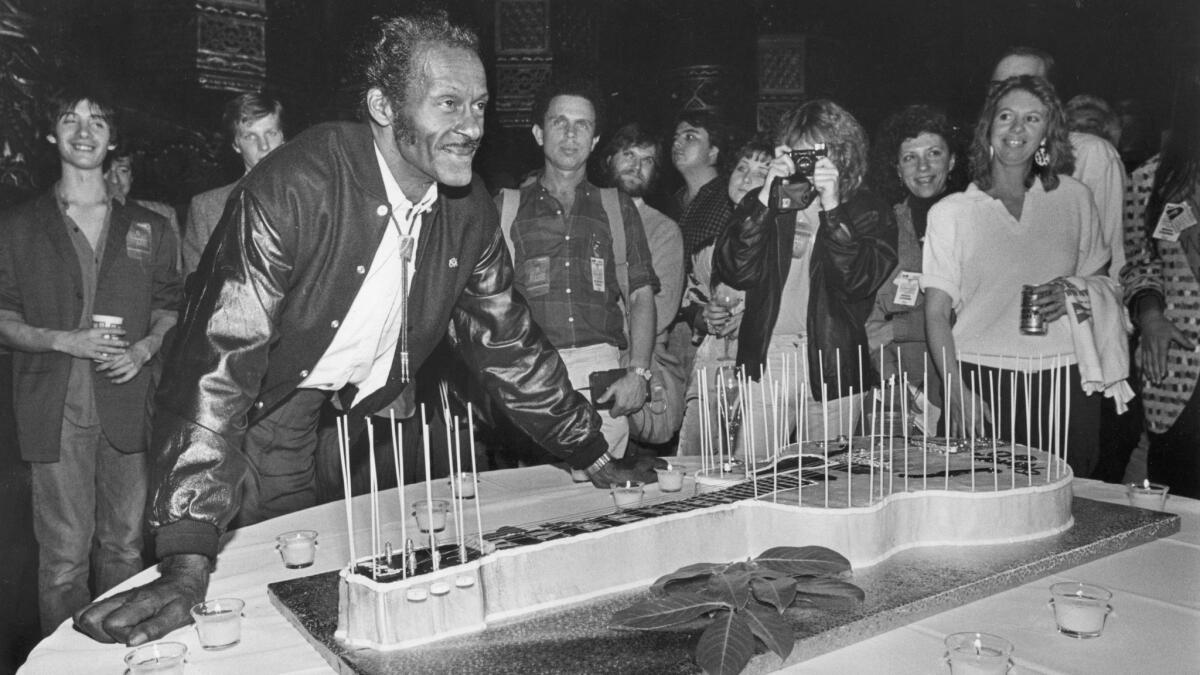 Chuck Berry, shown in St. Louis with a guitar-shaped cake for his 60th birthday in 1986, elevated the vocabulary of rock music from the outset in the 1950s.