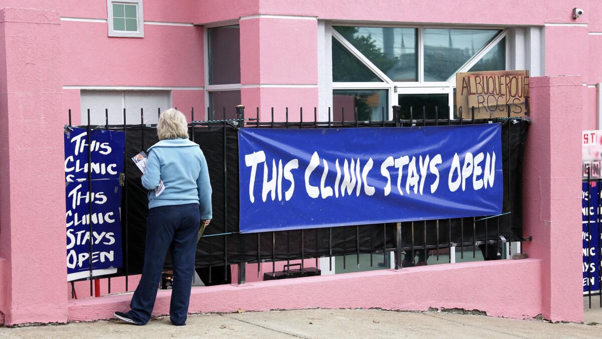Antiabortion protester Mary McLaurin calls out to a patient from behind a sign outside the Jackson Women's Health Organization clinic in Jackson, Miss.