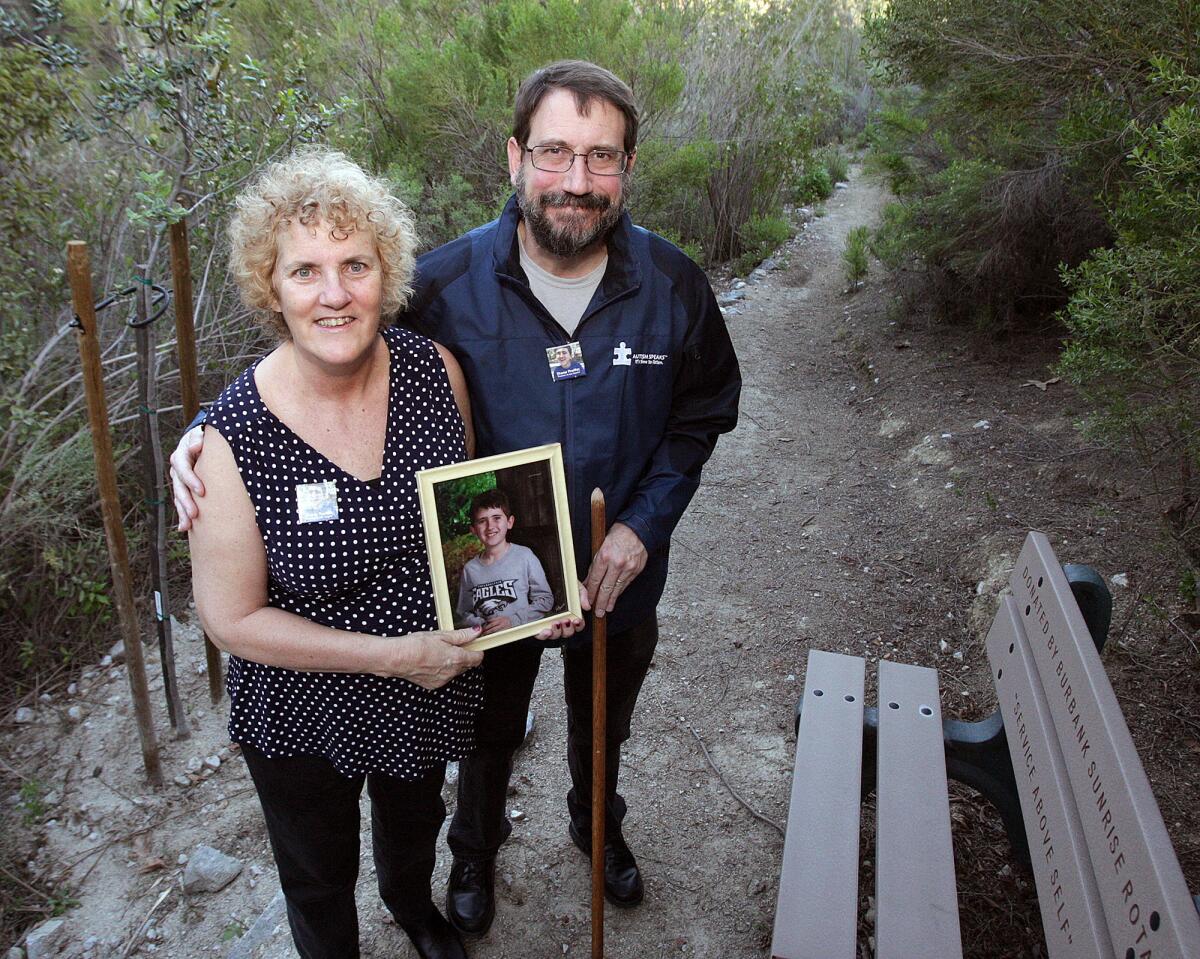 Nancy and Bill Proffitt, of Burbank, with a photo of their son Shane, at the Stough Canyon Nature Center on Friday, March 6, 2015. The Proffitts are standing on a roughly 130-foot trail that the Burbank City Council voted to rename the Shane Colin Proffitt Trail for their autistic, trail-loving, 17-year-old son who died recently.