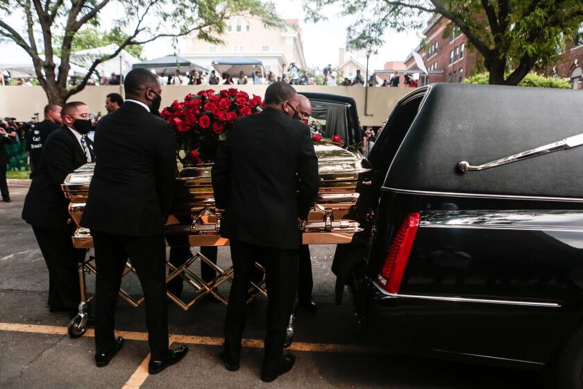 MINNEAPOLIS , MINNESOTA - JUNE 04: Hundreds of people cheer and chant as George Floyd's casket is placed into the hearse after his memorial service on Thursday, June 4, 2020 in Minneapolis , Minnesota. (Jason Armond / Los Angeles Times)