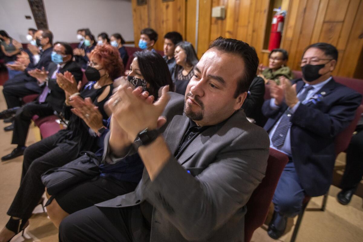 Rolando Flores, center, attends a wake for Tom Rivera at San Salvador Church in Colton.