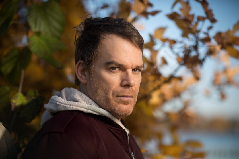 Actor Michael C. Hall in a hoodie and jacket, with autumn leaves as a backdrop