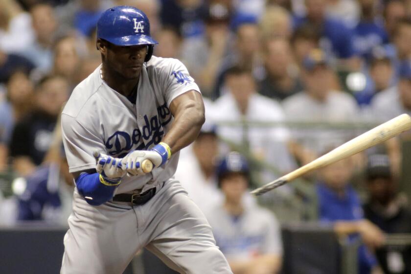 Dodgers center fielder Yasiel Puig breaks his bat on a check-swing during a loss to the Milwaukee Brewers on Friday.