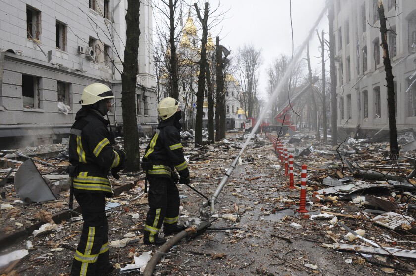 FILE - Firefighters extinguish a building of Ukrainian Security Service (SBU) after a rocket attack in Kharkiv, Ukraine's second-largest city, Ukraine, March 2, 2022. President Joe Biden has called Russia’s war on Ukraine a genocide and accused Vladimir Putin of committing war crimes. But his administration has for weeks grappled with how much intelligence it's willing to give Ukrainian forces trying to stop Putin. (AP Photo/Andrew Marienko, File)