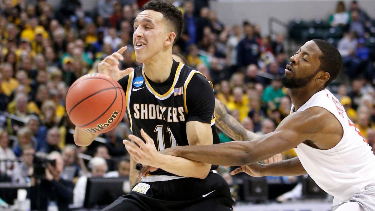 Wichita State guard Landry Shamet is fouled by Dayton guard Scoochie Smith on a drive to the basket during the first half.