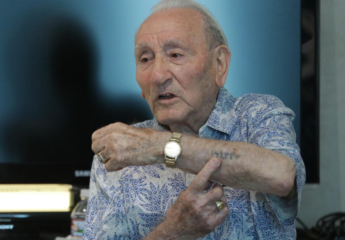 Holocaust survivor Joseph Alexander shows his identification tattoo from Auschwitz