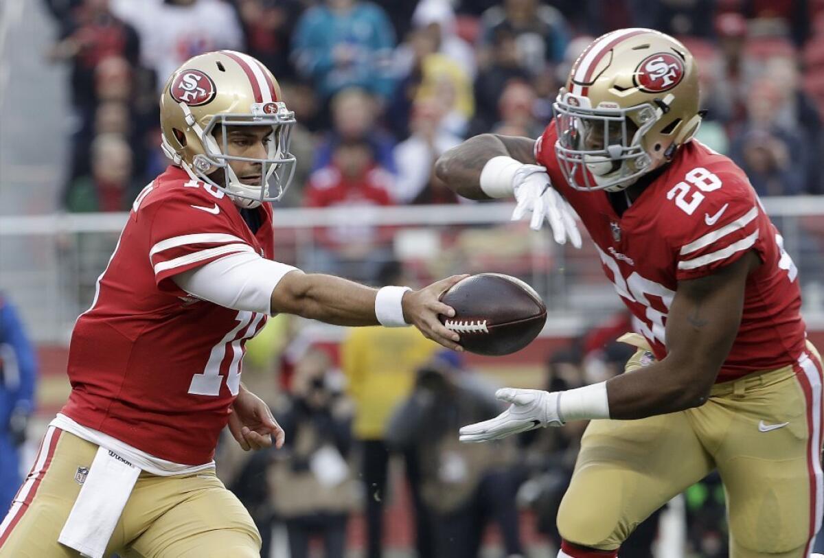 San Francisco quarterback Jimmy Garoppolo hands the ball off to running back Carlos Hyde during a game against the Jaguars.