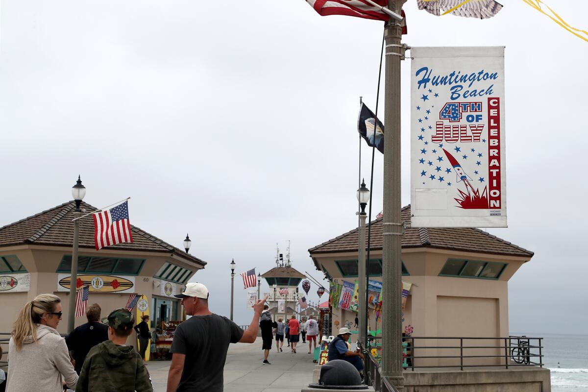 Fourth of July banners inform visitors of the city's planned celebration at Huntington Beach Pier on Wednesday.