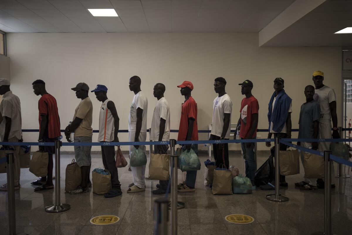 Survivors of the Senegalese pirogue found adrift queue at the airport.