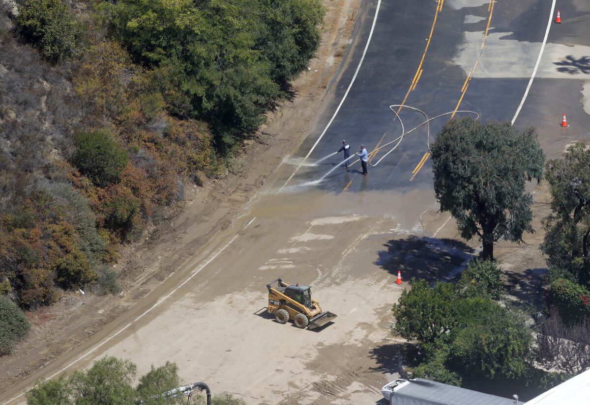Laguna Beach County Water District crews clear debris at the big bend in Laguna Canyon Road after a water main break.