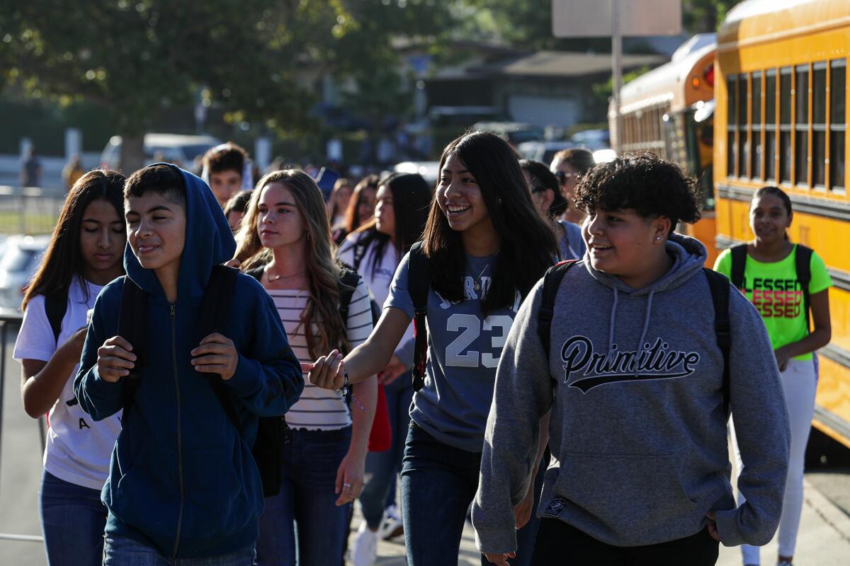 Students get off school buses.