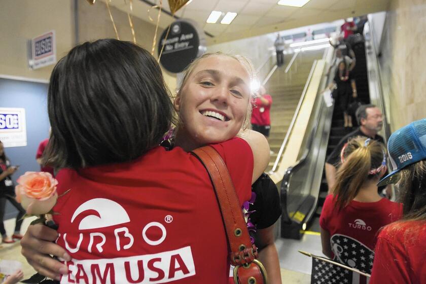 Laguna Beach resident Aria Fischer, right, gets a big hug from her mother, Leslie, after arriving Tuesday to John Wayne Airport from the 2016 Olympic Games in Rio de Janeiro. Fischer, along with her sister Makenzie, helped the U.S. women’s water polo team win gold.