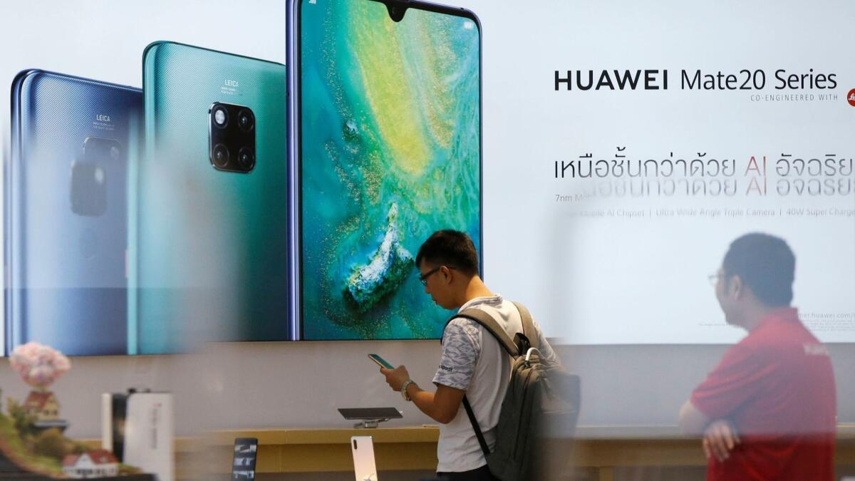 A customer inspects a Huawei smartphone at a Huawei store in Bangkok, Thailand, on May 21.