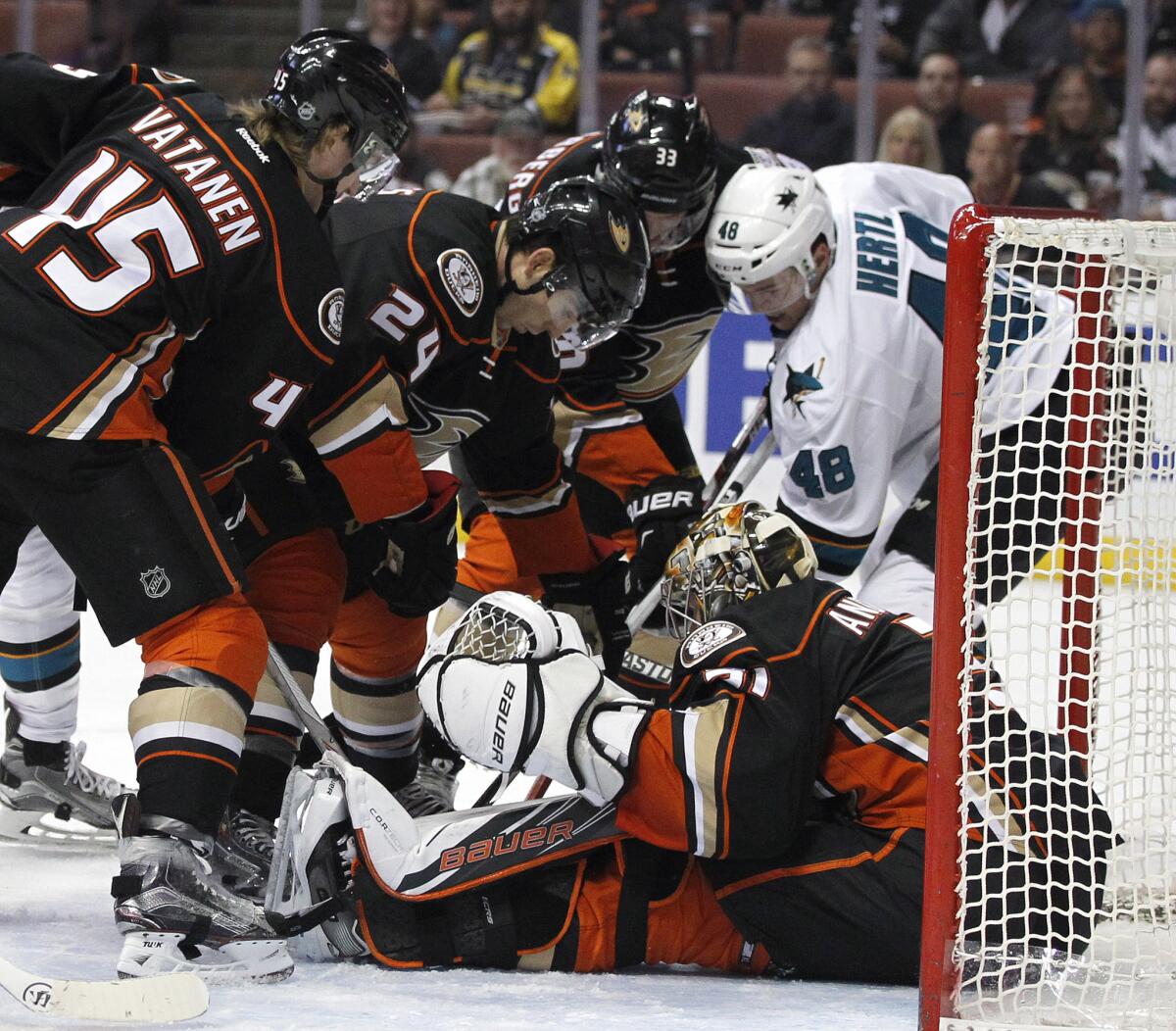 Anaheim goalie Frederik Andersen stops a shot by San Jose center Tomas Hertl while surrounded by a crowd of his teammates during the Ducks' 3-2 win over the Sharks.