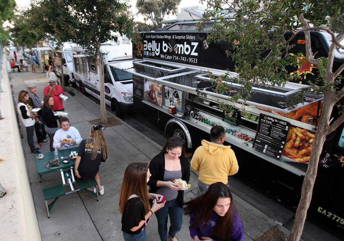 People, either waiting for their food or sitting on portable picnic tables in front of Ralphs in La Crescenta where food trucks gather for a weekly Food Truck Fundraiser for Crescenta Valley High School on Thursday, September 26, 2013.