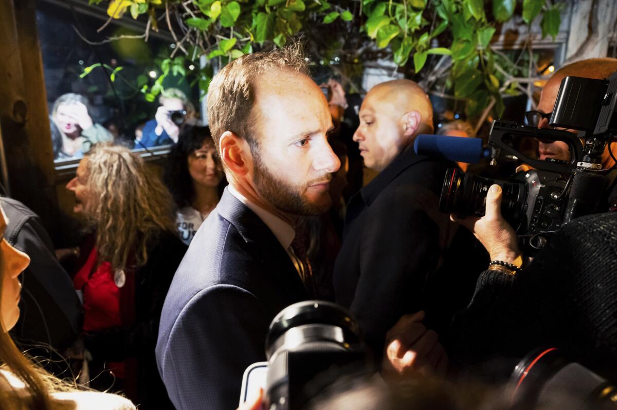 San Francisco Dist. Atty. Chesa Boudin looking somber as he talks with supporters.