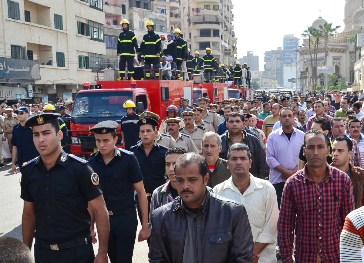 Egyptians escort firetrucks carrying coffins of three police officers who were killed during an attack against security forces on Monday in the Nile Delta city of Mansoura.