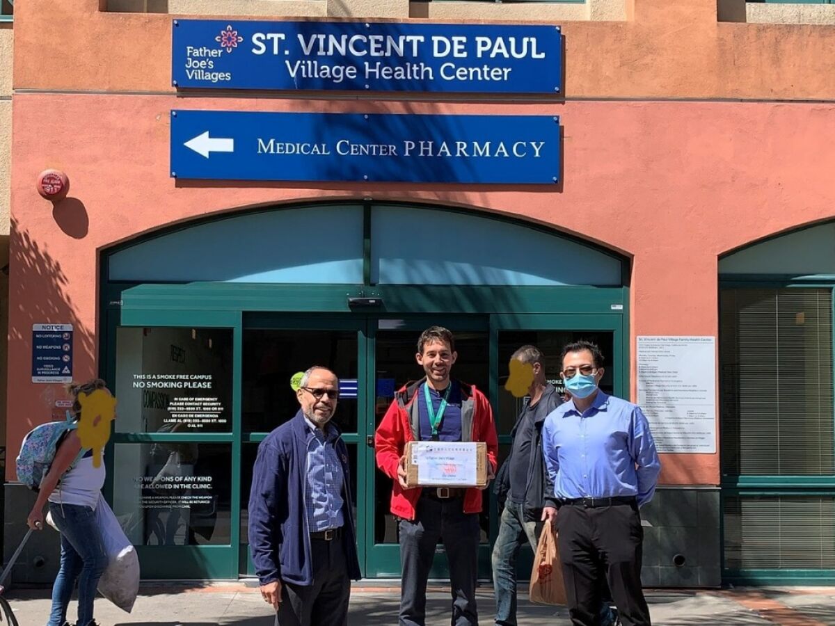 American Chinese Culture and Education Foundation President Jing Zhao (right) brings donated personal protective equipment at Father Joe's Village CEO Deacon Jim F. Vargas (left) and Medical Director Jeffrey Norris (center).