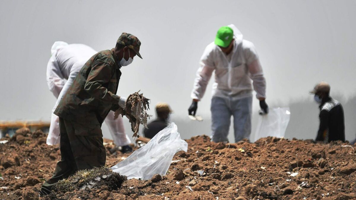 Forensics experts comb through the dirt for debris at the crash site of the Ethiopian Airlines Boeing 737 Max aircraft.