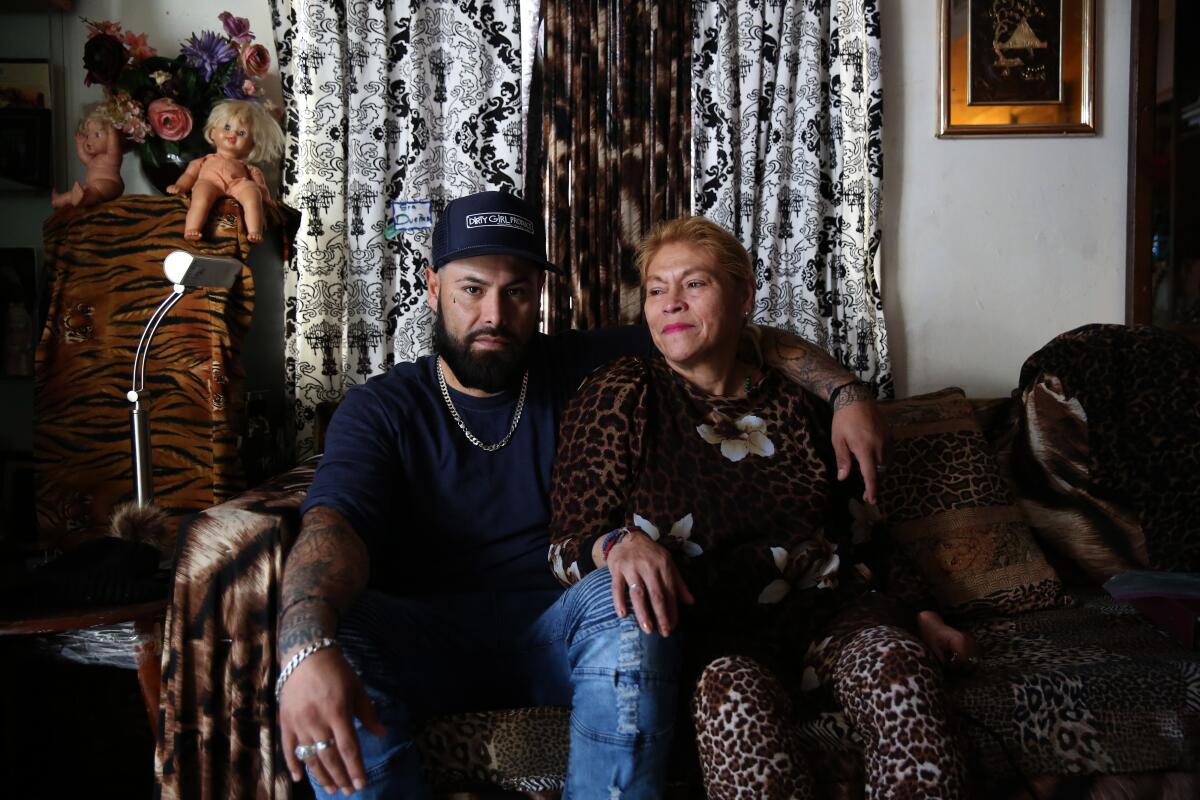 Noe Torres sits next to his mother, Blanca Due?as, in their East L.A. apartment.
