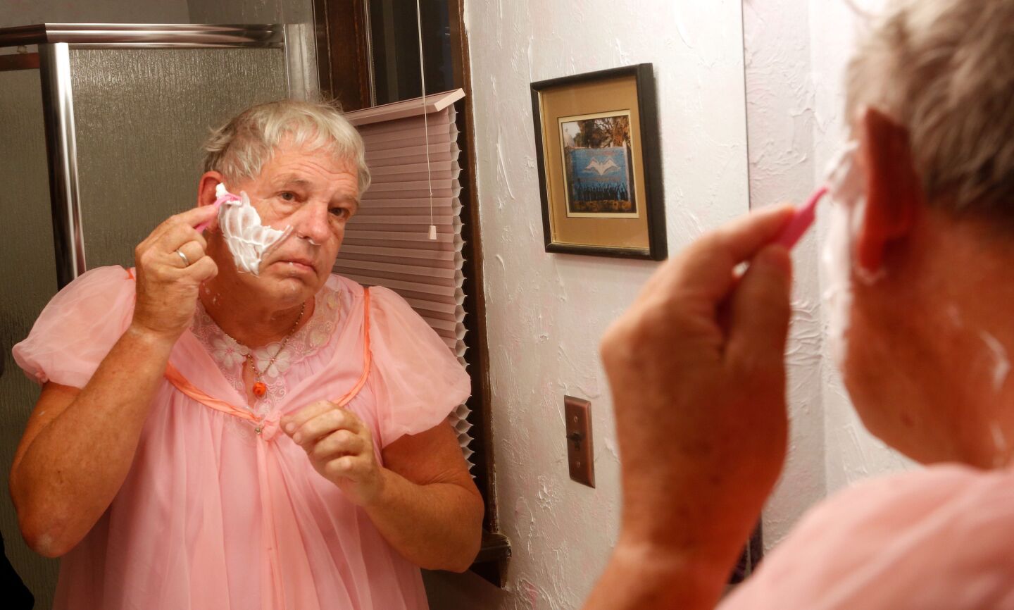 Goodwin, wearing the pink nightgown he sleeps in, shaves before breakfast at home in Douglas, Wyo., the town where he was born.