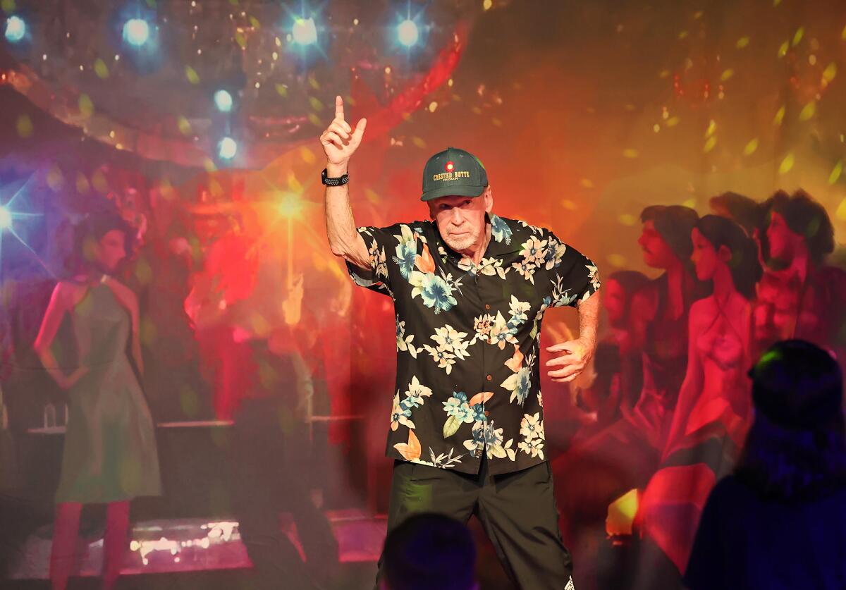 Bob Kendrick strikes a pose made famous by John Travolta in the movie "Saturday Night Fever" at the "Rewind" exhibit.
