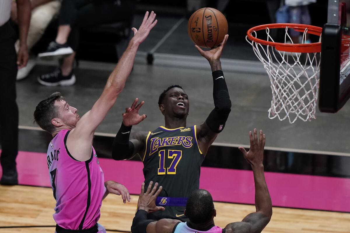 Lakers guard Dennis Schroder drives to the basket as Miami Heat guard Goran Dragic defends.
