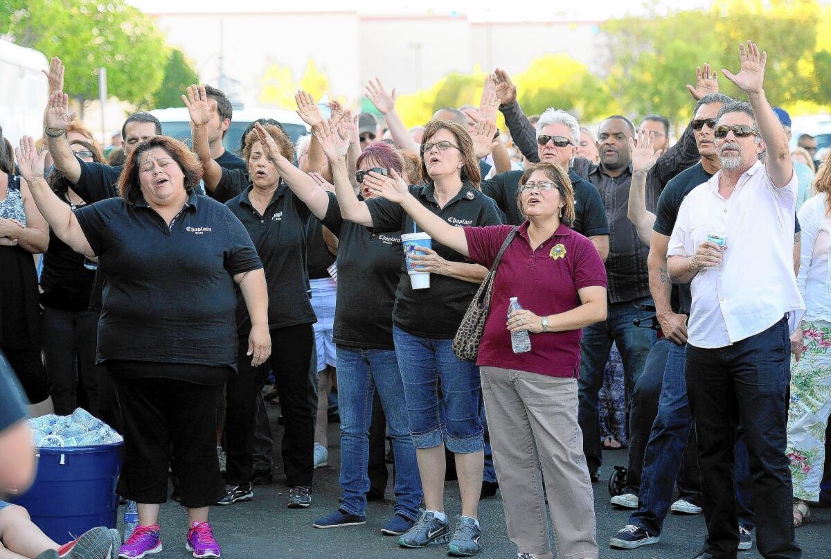 People sing during a vigil this week in Las Vegas after two police officers and another person were fatally shot by a married couple who, police say, later died in a murder-suicide.