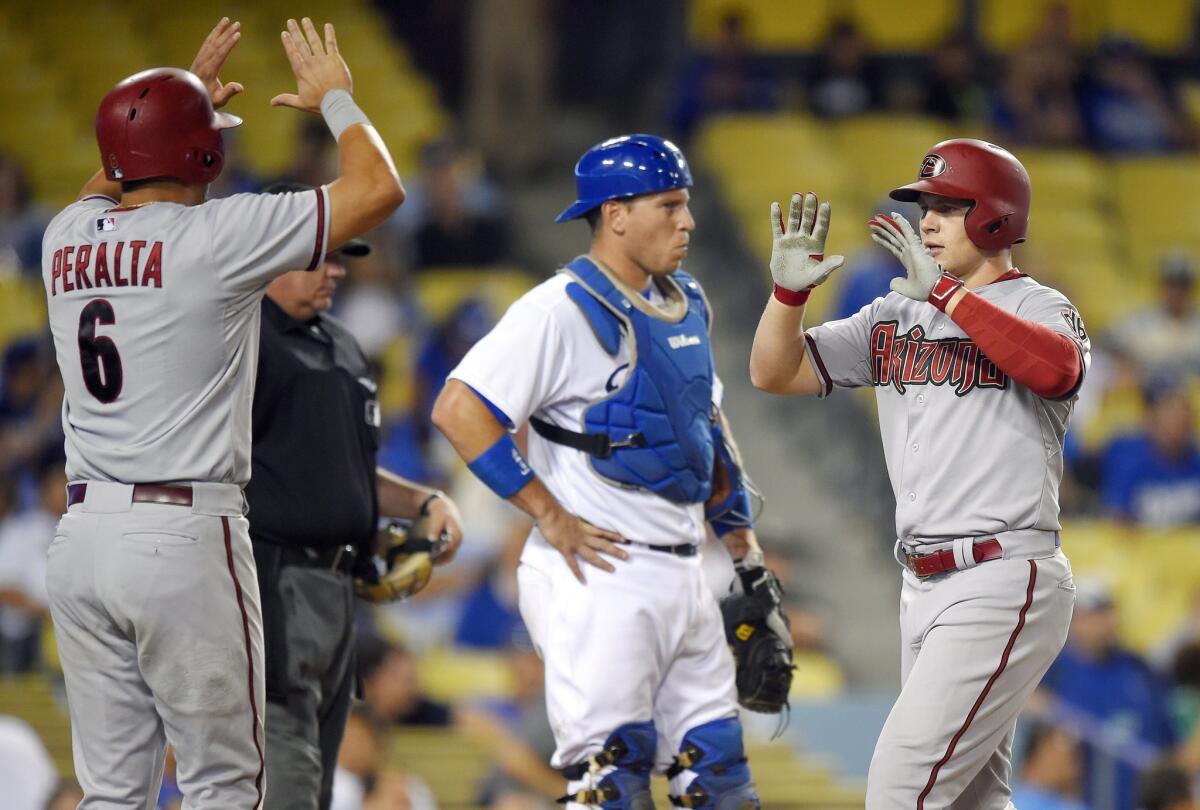 Arizona Diamondbacks' Brandon Drury, right, is congratulated by David Peralta, left, after hitting a three-run home run as Los Angeles Dodgers catcher A.J. Ellis stands at the plate.