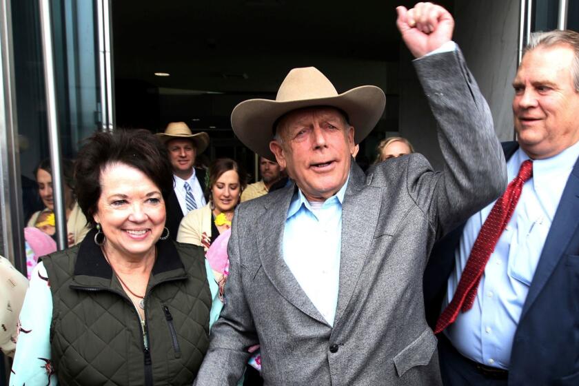 Cliven Bundy walks out of federal court with his wife Carol on Monday, Jan. 8, 2018, in Las Vegas, after a judge dismissed criminal charges against him and his sons accused of leading an armed uprising against federal authorities in 2014. (K.M. Cannon/Las Vegas Review-Journal via AP)