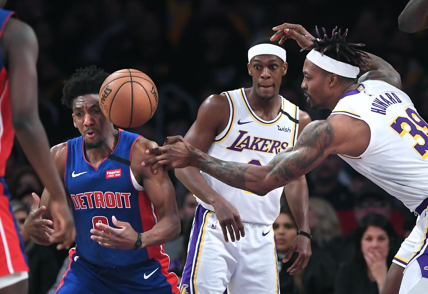 Lakers center Dwight Howard, right, battles for a loose ball with Pistons guard Langston Galloway as Lakers guard Rajon Rondo looks on during the fourth quarter.
