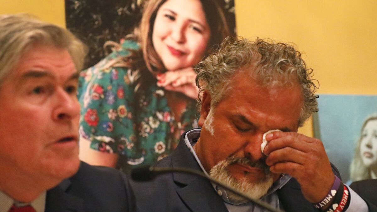Salvador Albert Corado, father of Melyda Corado, who was shot and killed by LAPD officers at a Trader Joe's in Silver Lake, during a press conference with a family attorney, John Taylor. Melyda's photo is in the background.