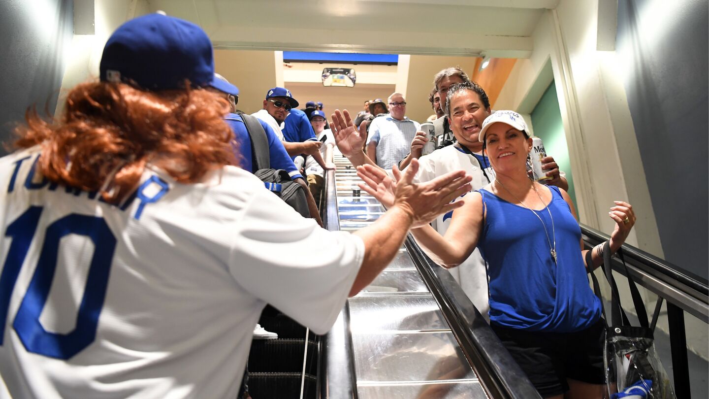 Mike Eliason, dressed in a Justin Turner wig, high-fives Dodgers fans before Game 2.