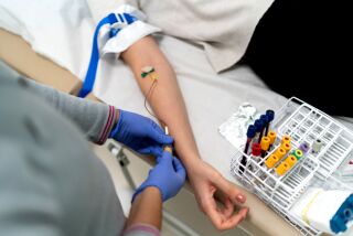 Nurse drawing blood sample from patient vein
