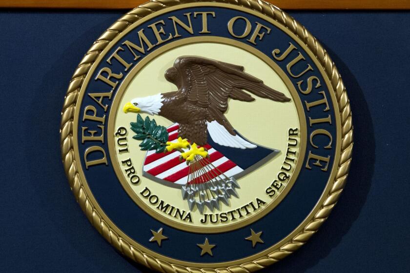 The Department of Justice seal is seen, ahead of a news conference of Deputy Attorney General Rod Rosenstein speaks announcing the indictment against international computer hacking, at Department of Justice in Washington, Wednesday, Nov. 28, 2018. The Justice Department says two Iranian computer hackers have been charged in connection with multimillion-dollar cybercrime and extortion scheme that targeted U.S. government agencies and businesses. (AP Photo/Jose Luis Magana)