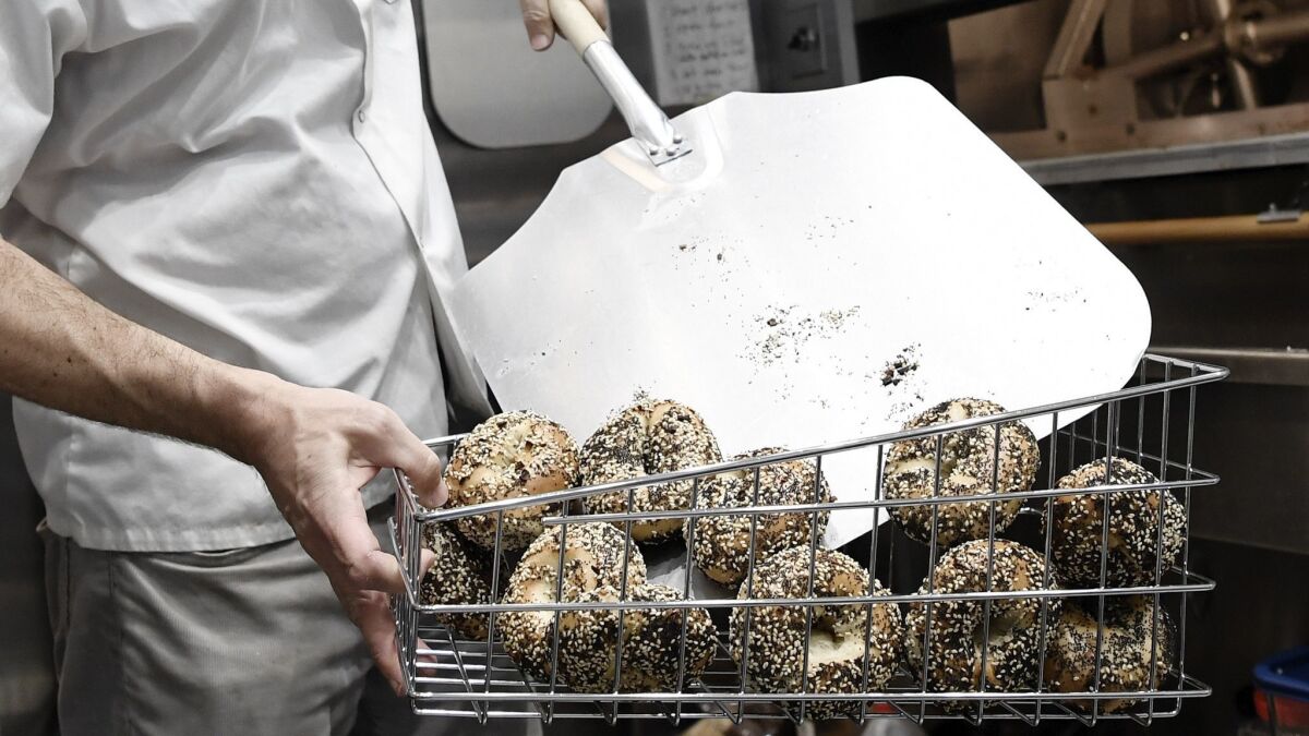Jason Kaplan, baker and owner of Maury's Bagels, pulls bagels out of his oven.