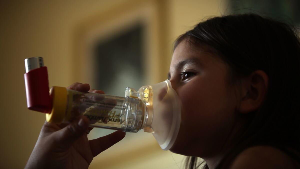 A 6-year-old uses an inhaler to help ease her asthma symptoms. Asthma is one of the health conditions projected to increase as the planet gets warmer, experts say.